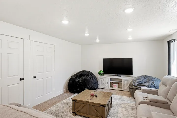 Recessed lighting illuminates this bright room featuring white walls and a light-colored, textured ceiling