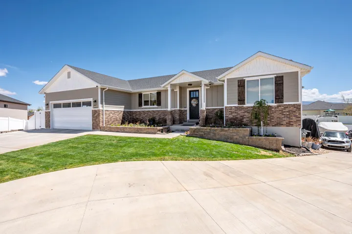 Ranch-style residence featuring a two-car garage, brick veneer accents, and horizontal siding