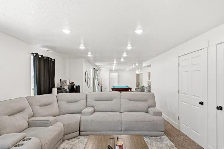 Spacious recreation room featuring recessed lighting, white walls, and a billiards table