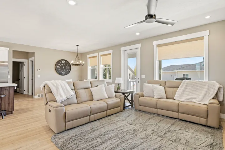 Open-concept living area featuring light wood-finish flooring, recessed lighting, and a contemporary ceiling fan