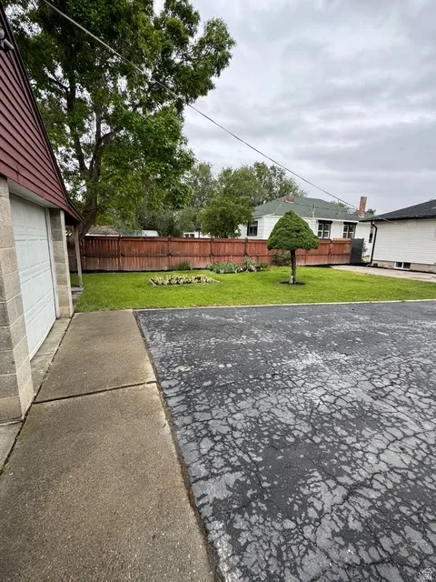 Spacious yard featuring a manicured lawn and a privacy fence