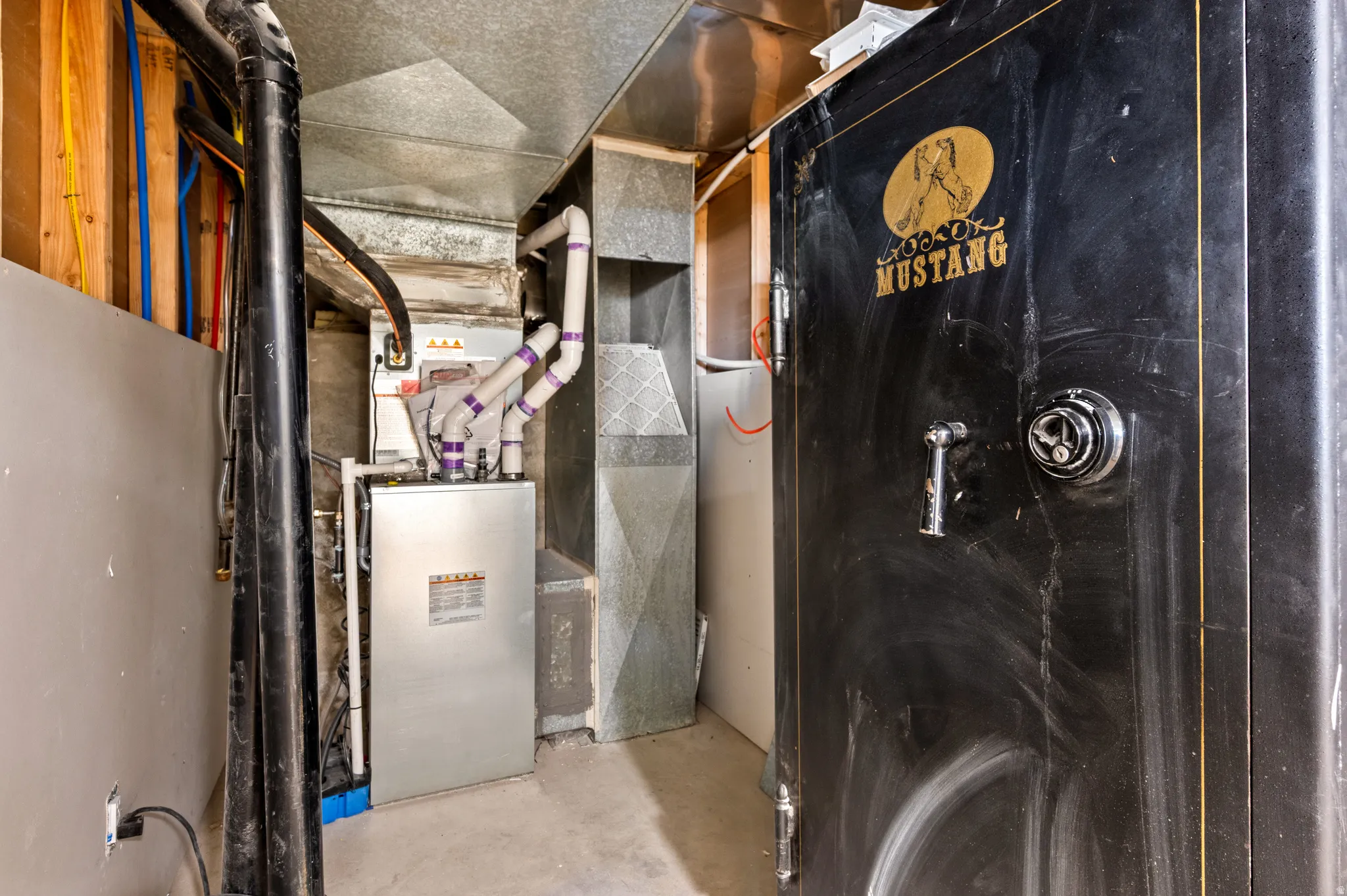 HVAC system present, featuring visible ductwork and piping.  Mid 20th-Century Mustang gun safe provides a significant deterrent and a reasonable level of protection for personal valuables