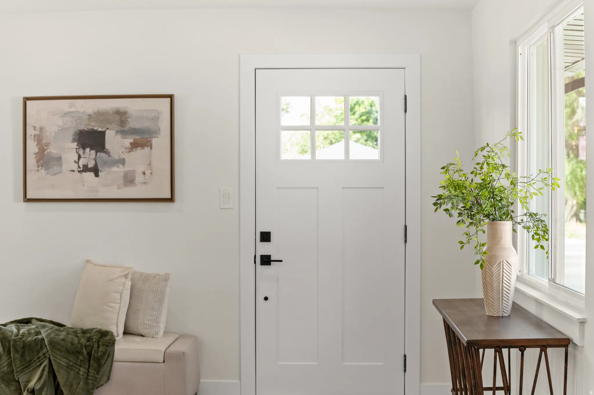Entryway featuring a white paneled door with glass inserts, matte black hardware, and a large window with white trim