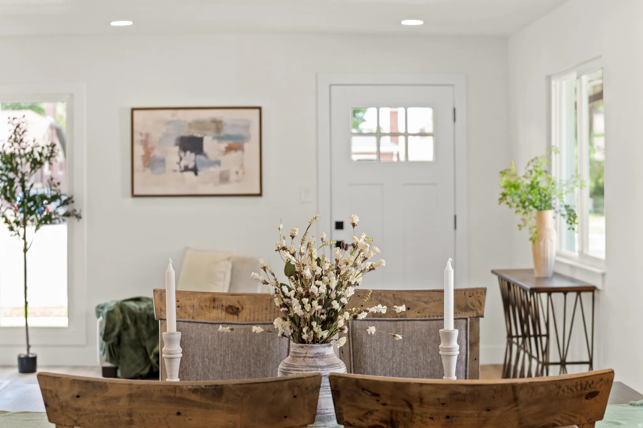 Open concept interior with recessed lighting, light wood-finish flooring, and a white paneled door with glass inserts