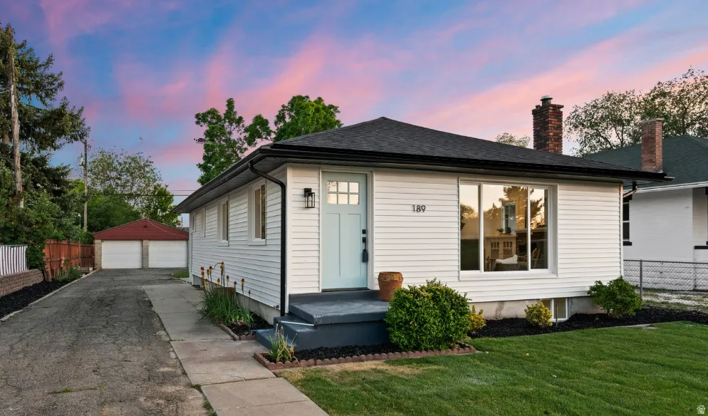White siding exterior with a light blue front door and black trim details