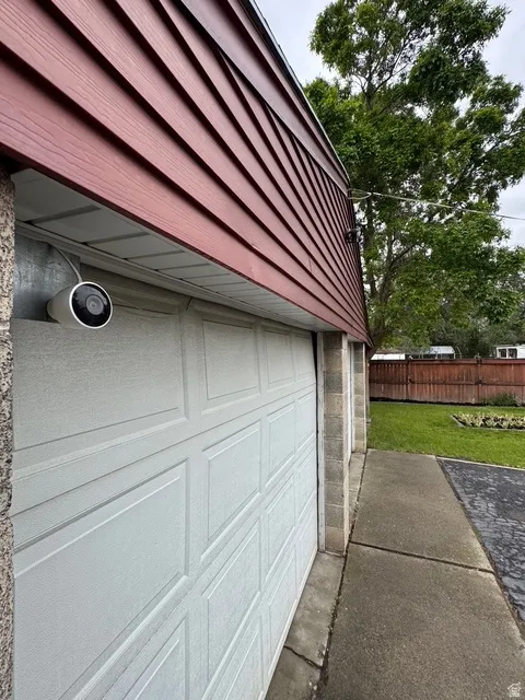 White paneled garage door with block wall siding and red horizontal siding