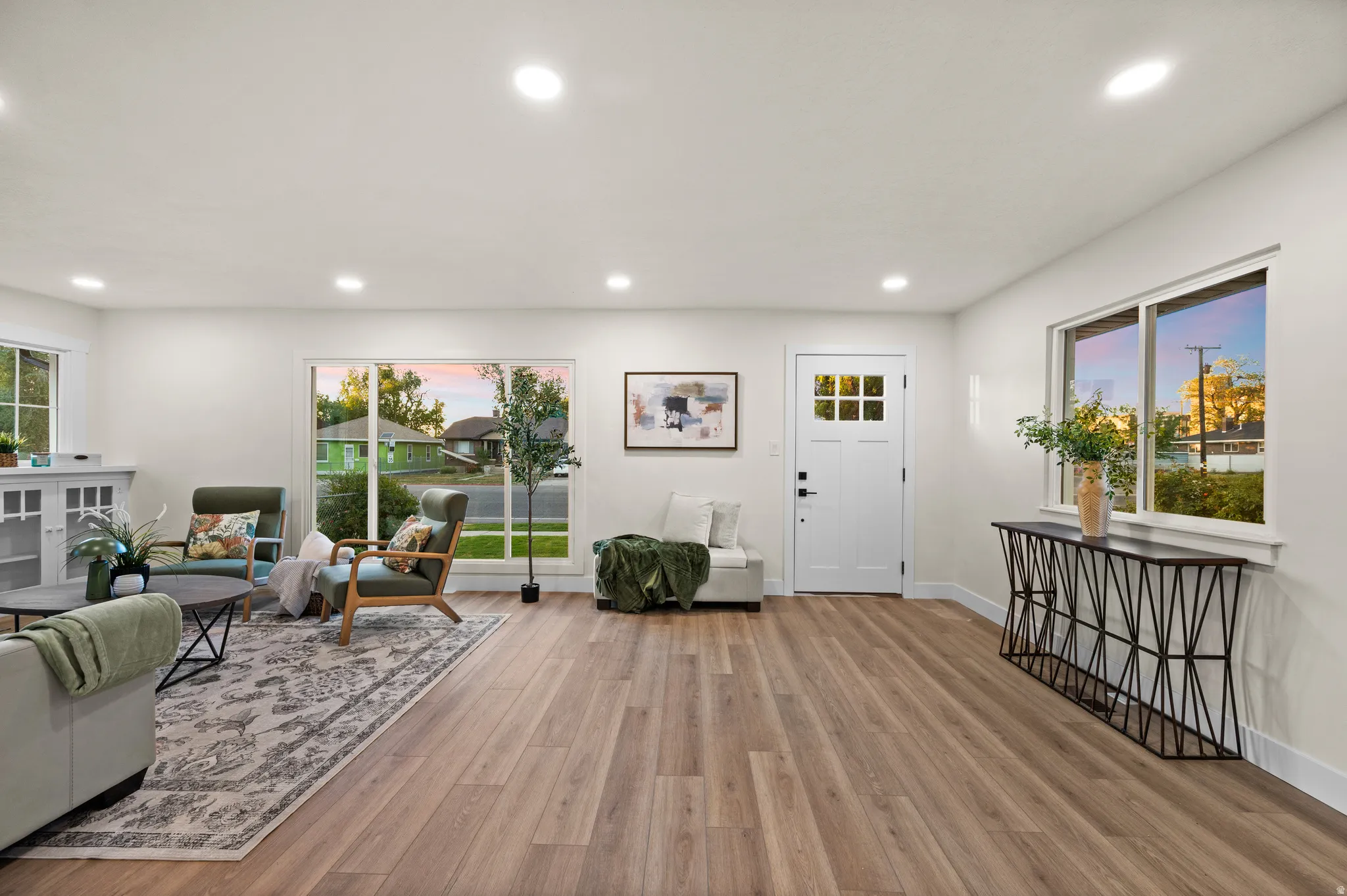 Open concept living area featuring wood-finish flooring, white walls, and recessed lighting