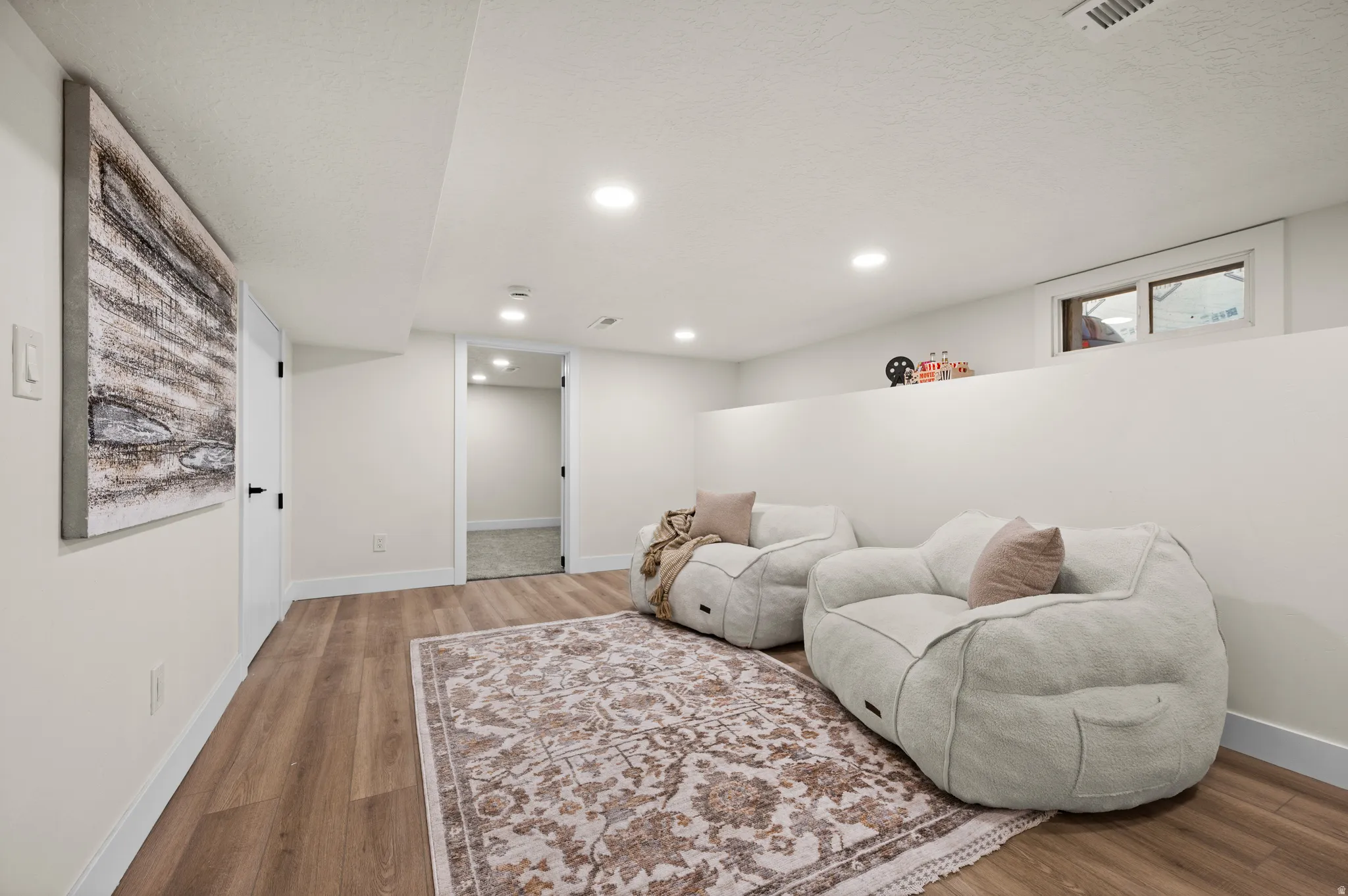 Spacious room featuring wood-finish flooring, recessed lighting, and a neutral wall palette