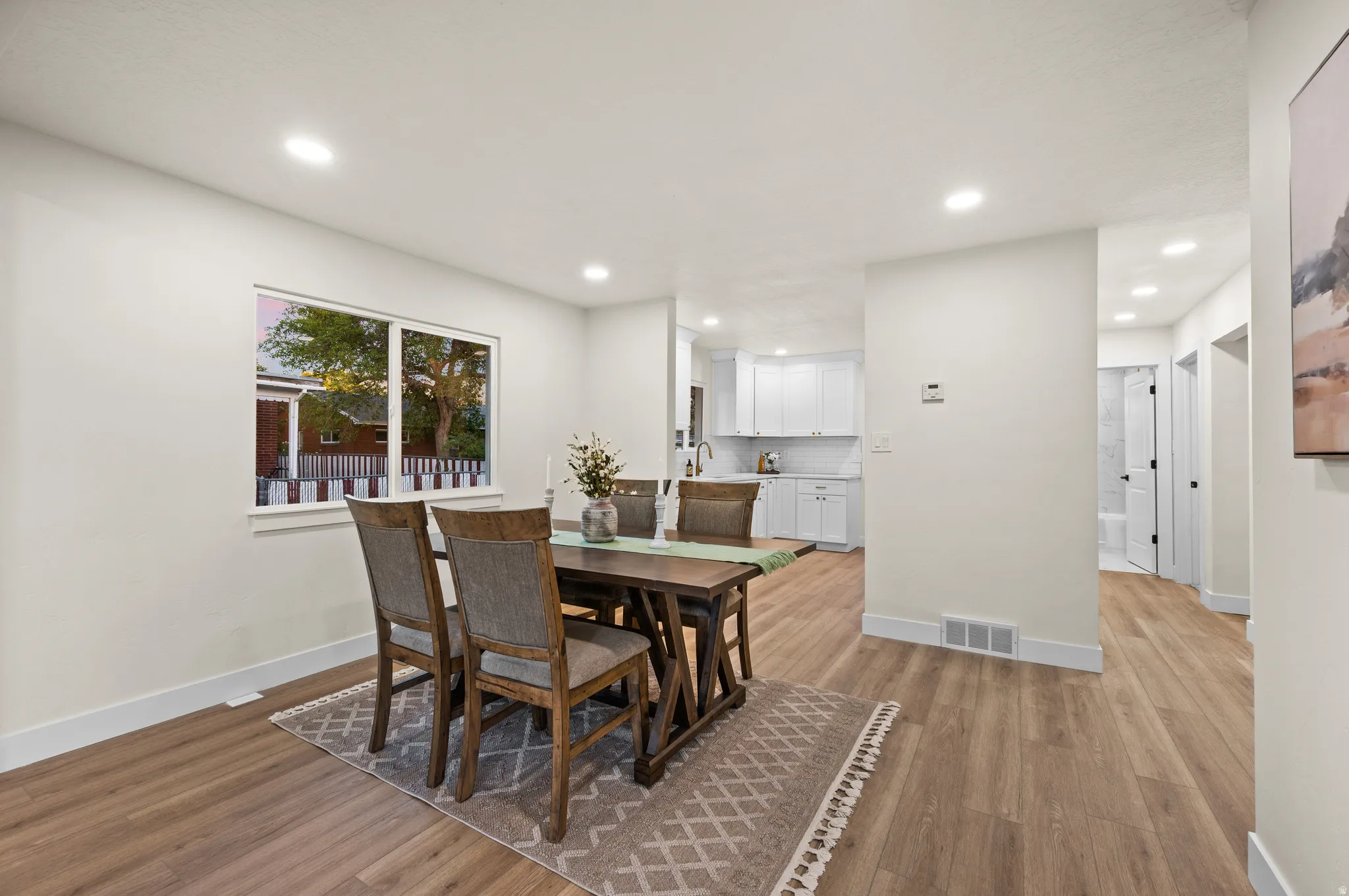 Open-concept living space featuring wood-finish flooring, recessed lighting, and a neutral color palette