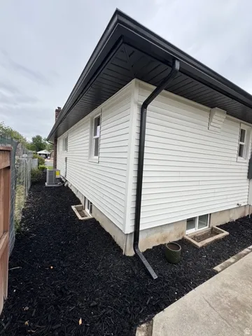 White horizontal siding with contrasting black soffit, fascia, and gutters
