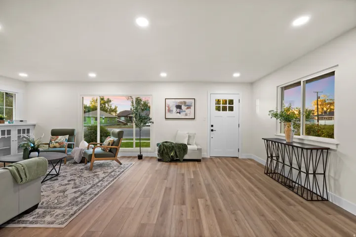 Open concept living area featuring wood-finish flooring, white walls, and recessed lighting