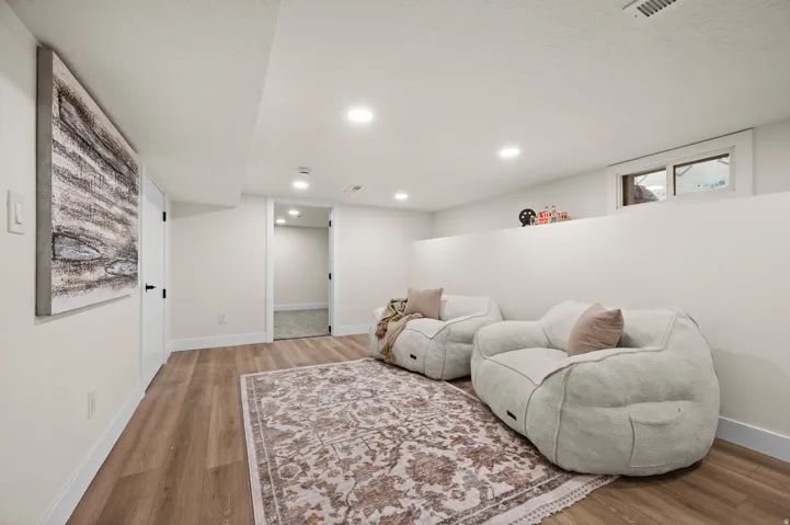 Spacious room featuring wood-finish flooring, recessed lighting, and a neutral wall palette