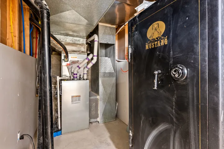 HVAC system present, featuring visible ductwork and piping.  Mid 20th-Century Mustang gun safe provides a significant deterrent and a reasonable level of protection for personal valuables