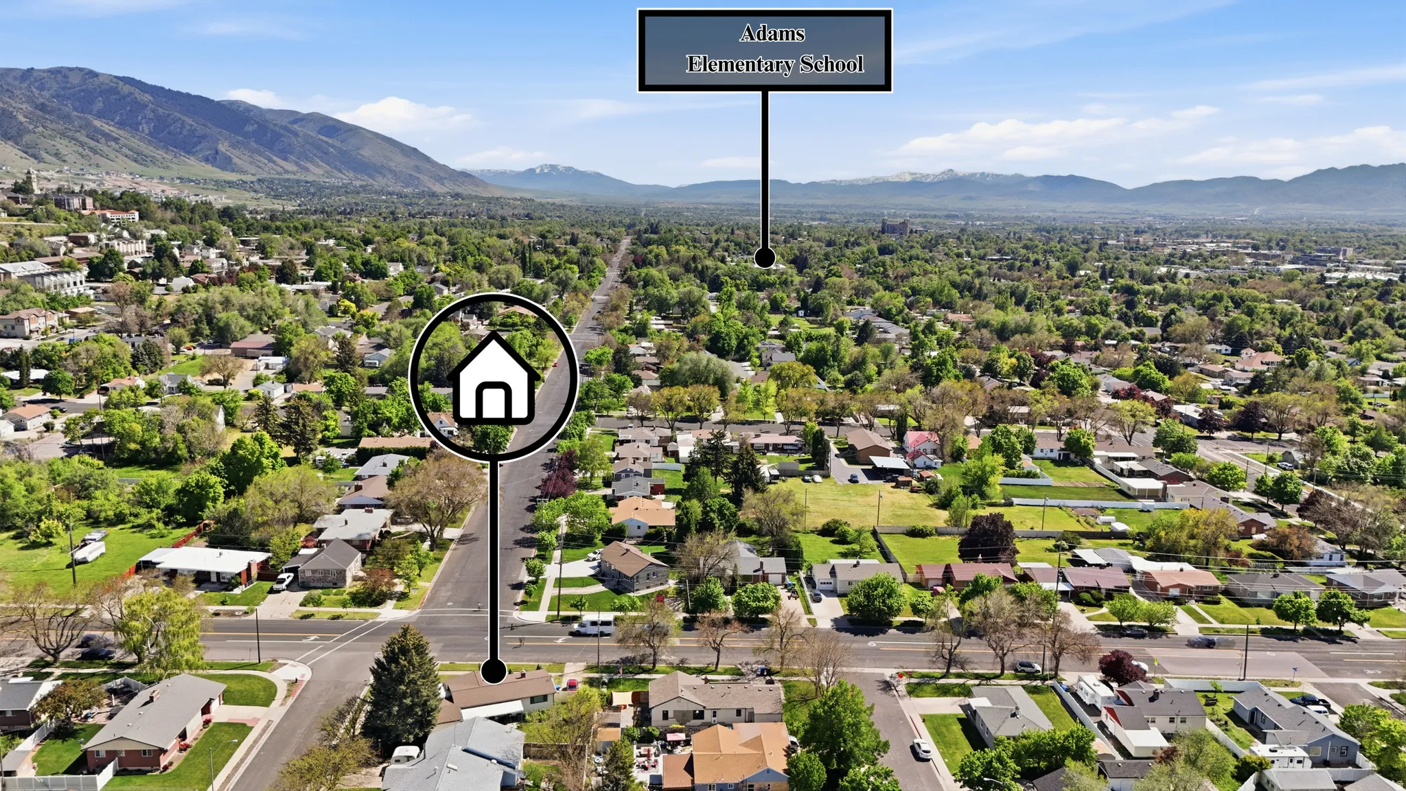 Aerial perspective showcasing a residential neighborhood with tree-lined streets and mountain backdrops