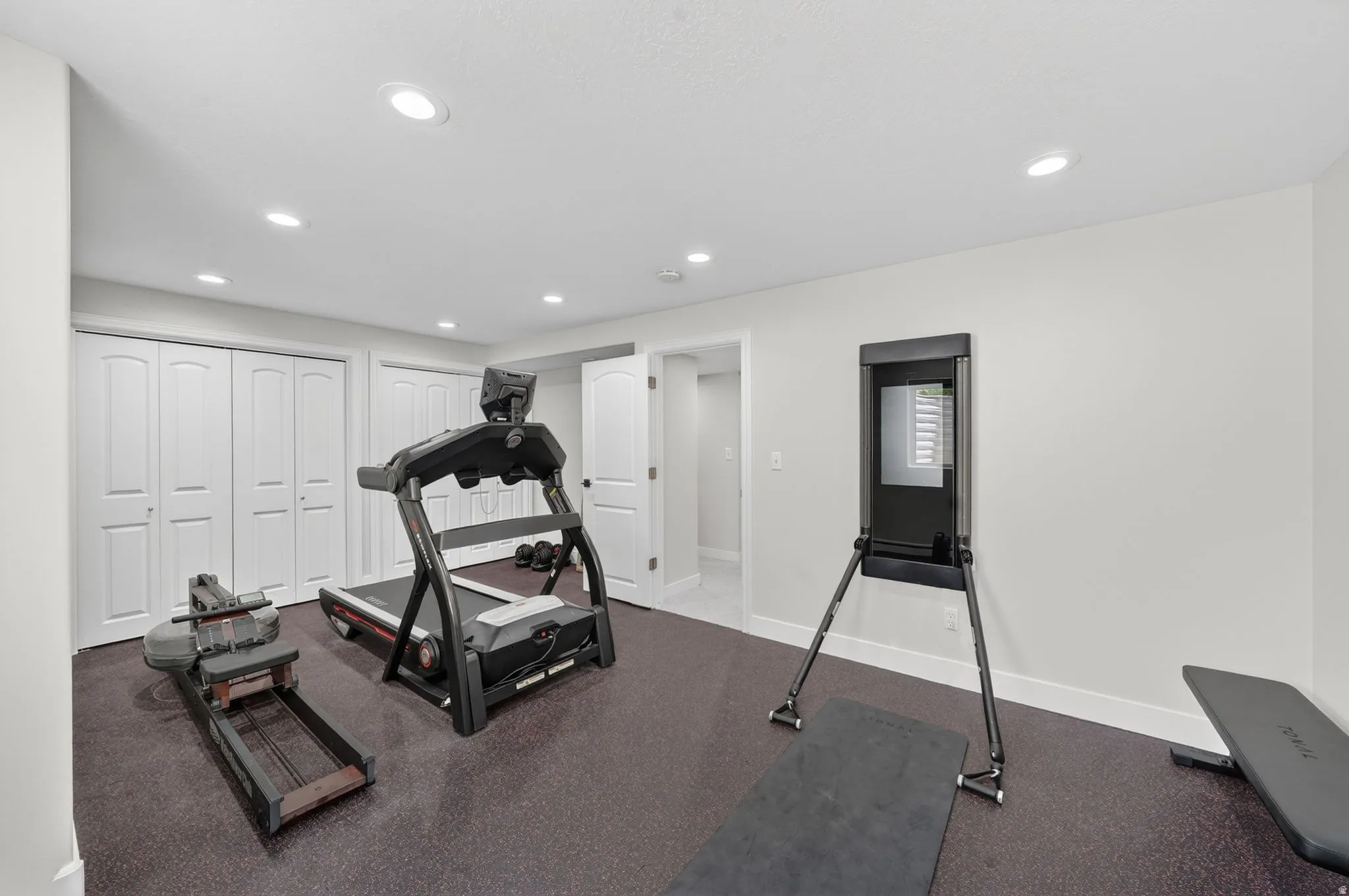 Recreational room featuring recessed lighting, a neutral color palette, and durable dark-toned flooring