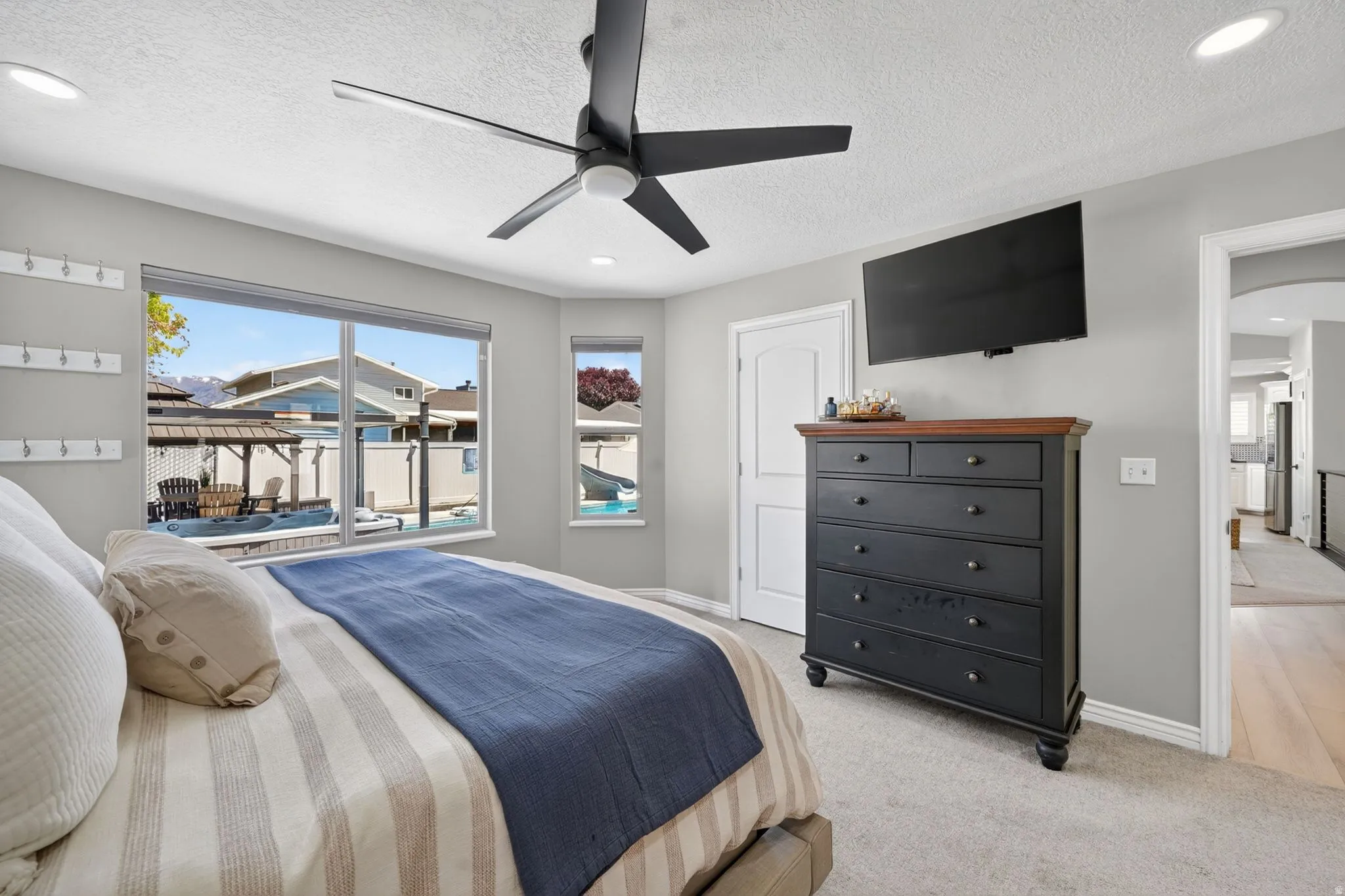 Bedroom featuring a large window, secondary window, ceiling fan, recessed lighting, and carpet flooring