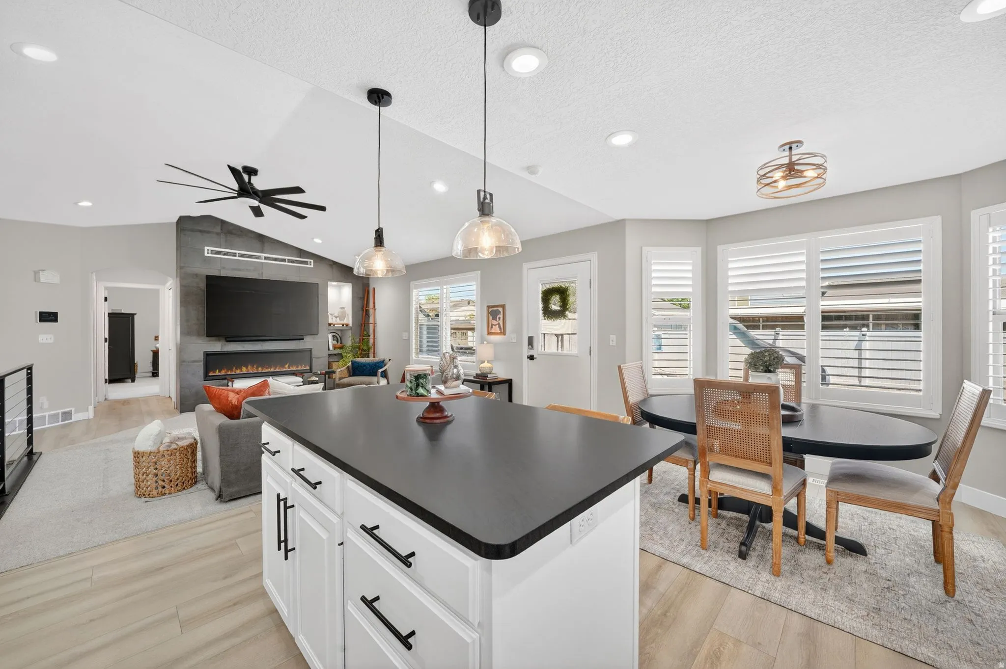 Kitchen island with a dark countertop and white cabinetry featuring dark hardware