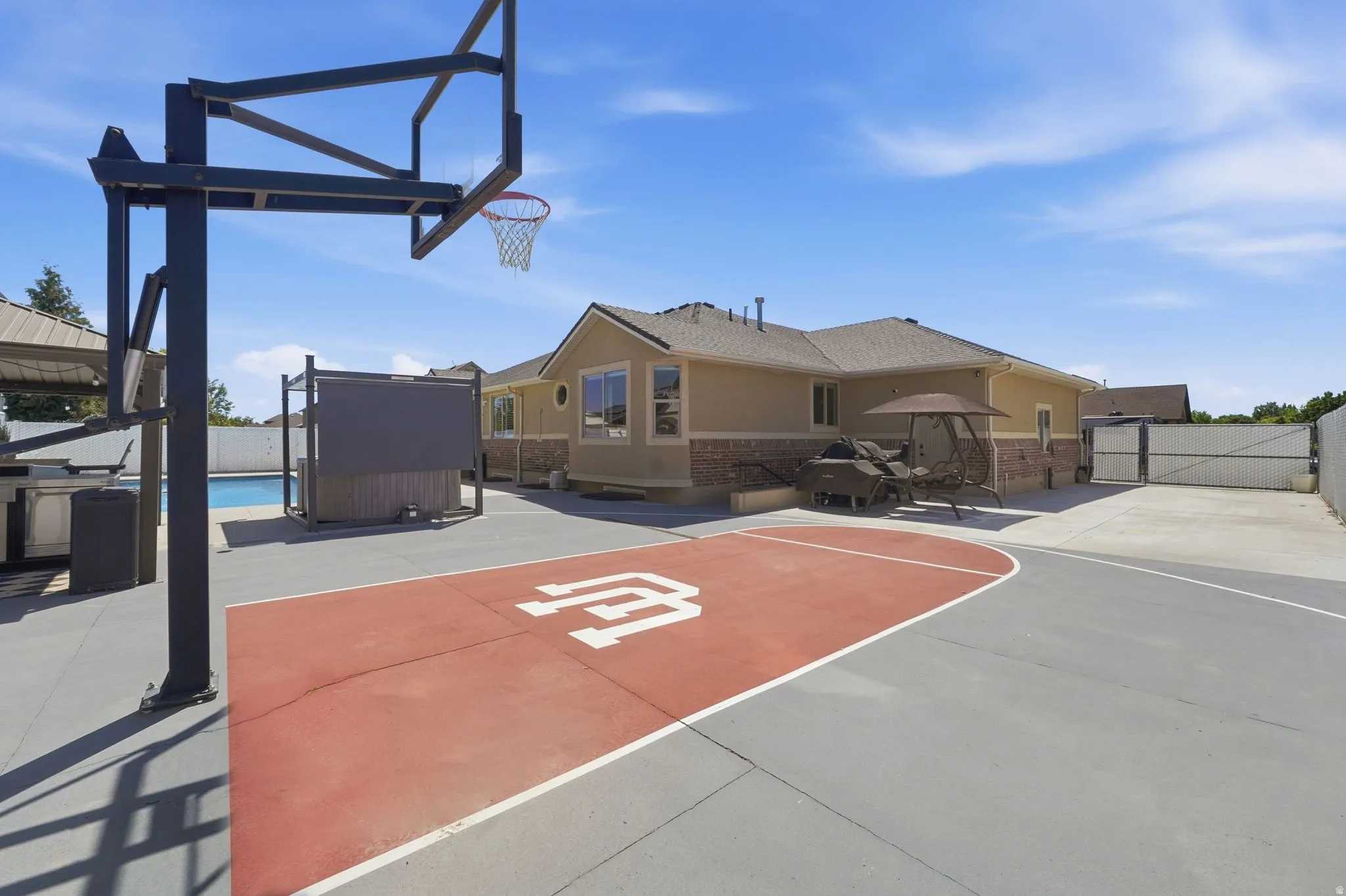 Outdoor sport court with integrated basketball hoop