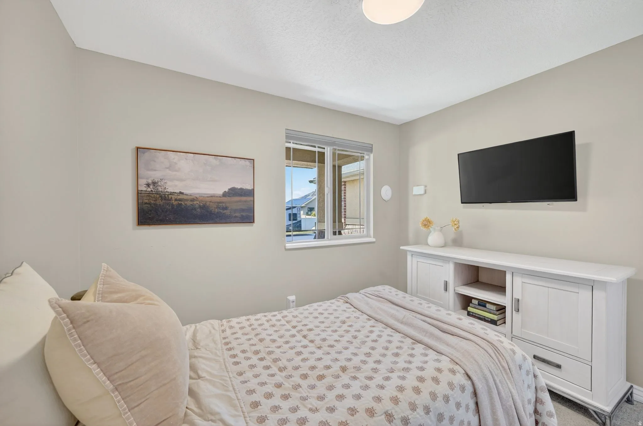 Neutral tone bedroom featuring a single window with blinds