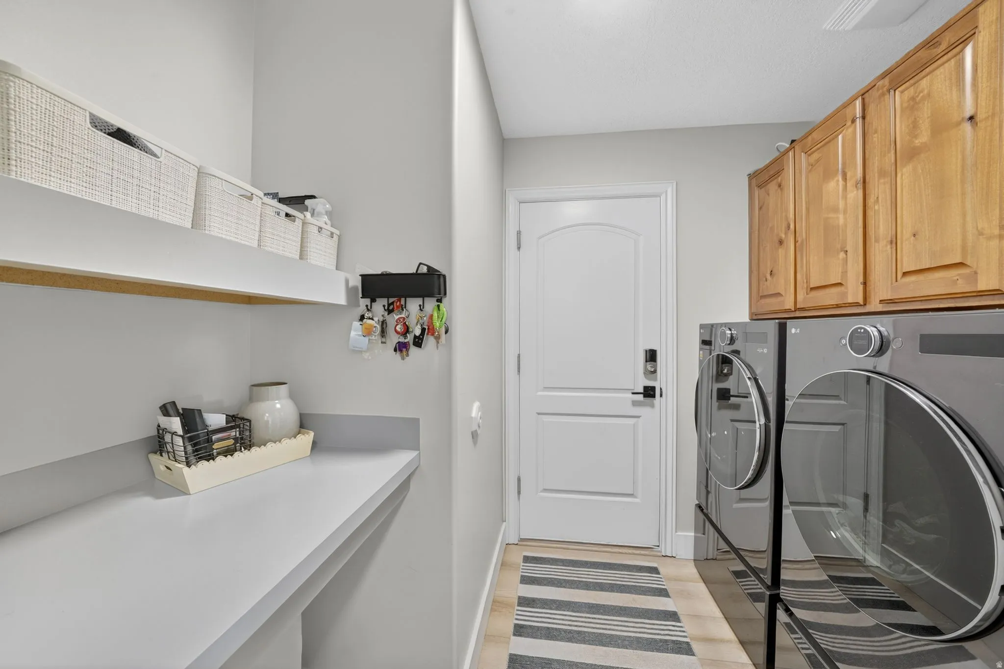 Dedicated utility area featuring wood-finish flooring and light gray walls