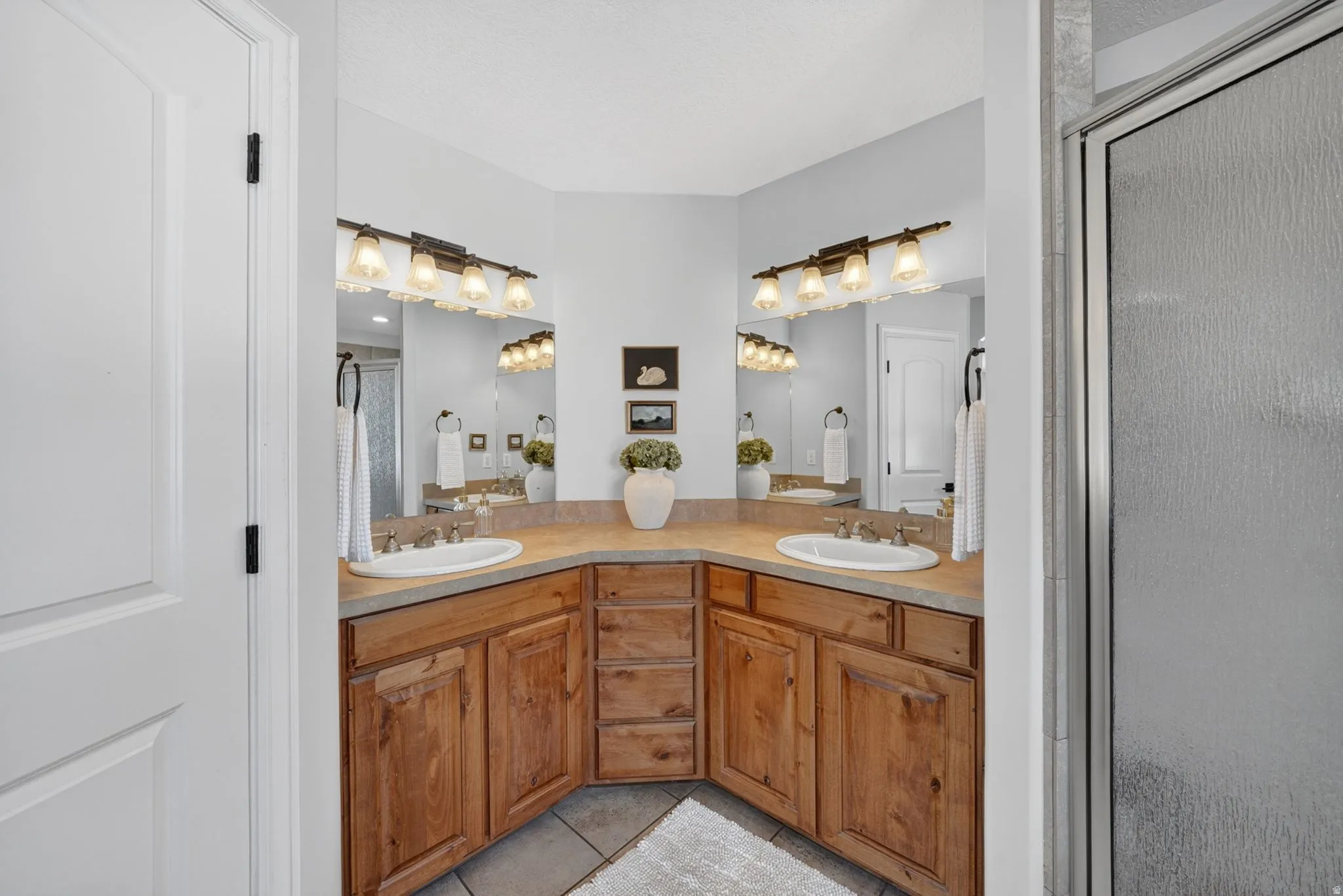 Dual vanity with wood cabinetry and a neutral countertop