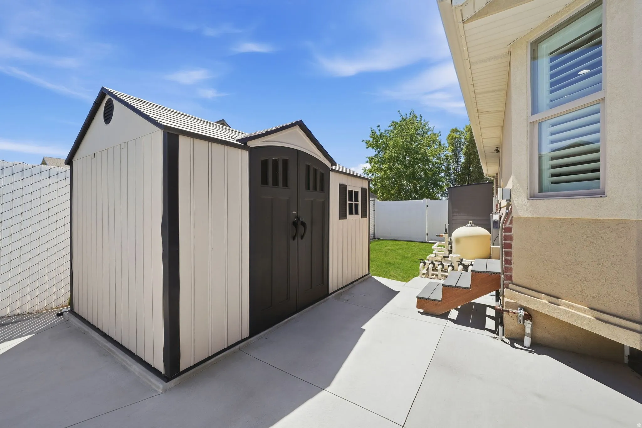 Outdoor storage shed with dual barn-style doors and shingled roof