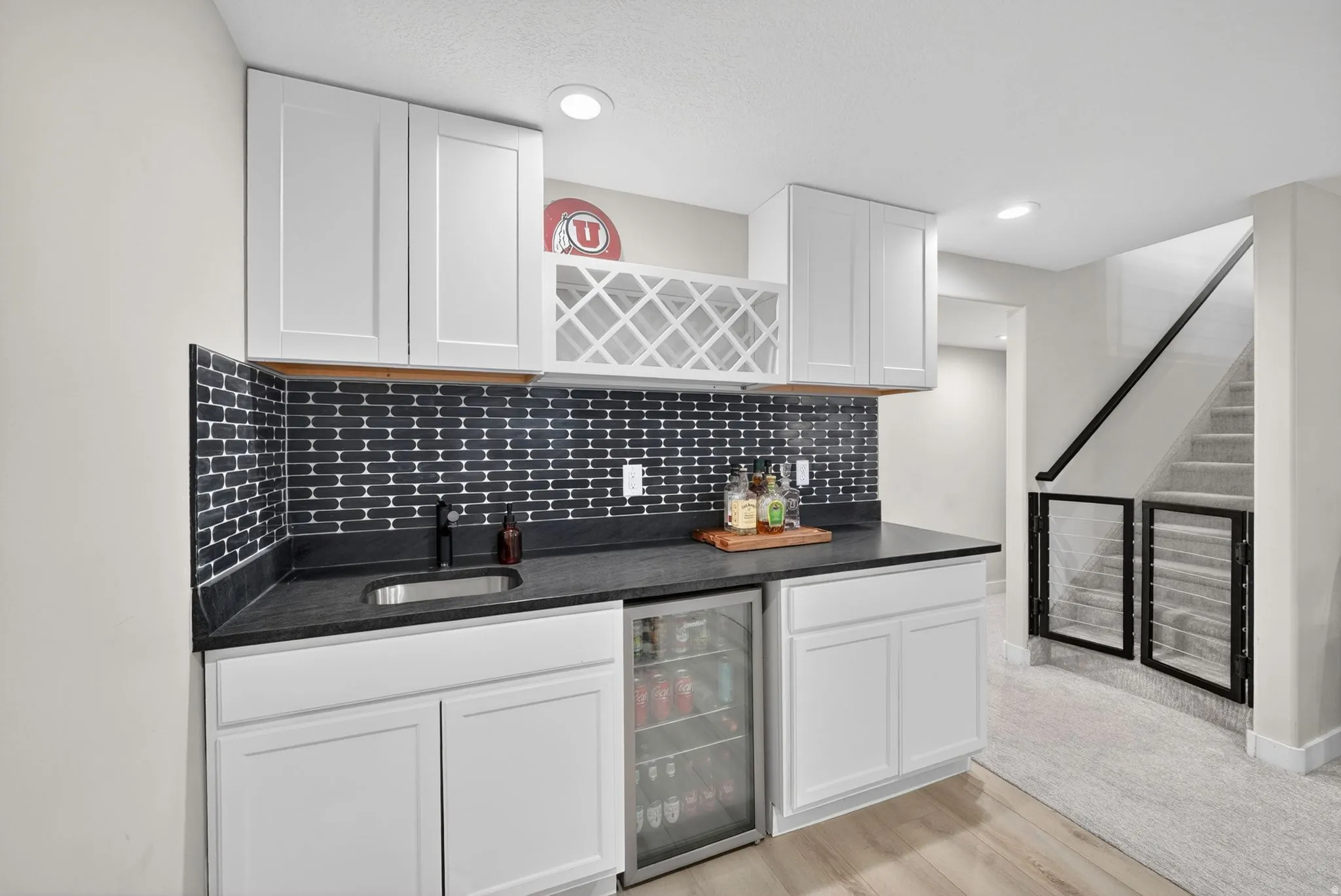 Wet bar featuring white shaker cabinetry, dark subway tile backsplash, and a built-in beverage refrigerator