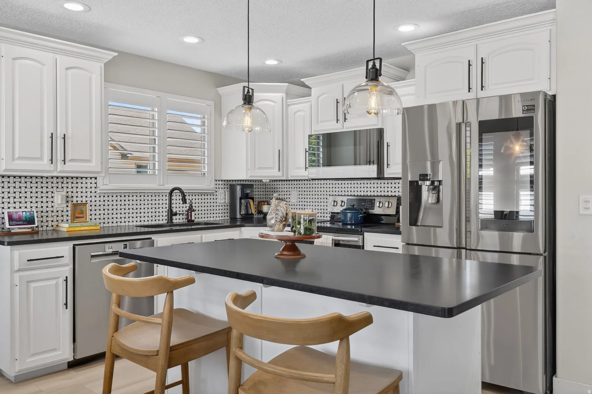 Bright kitchen featuring white cabinetry and black hardware