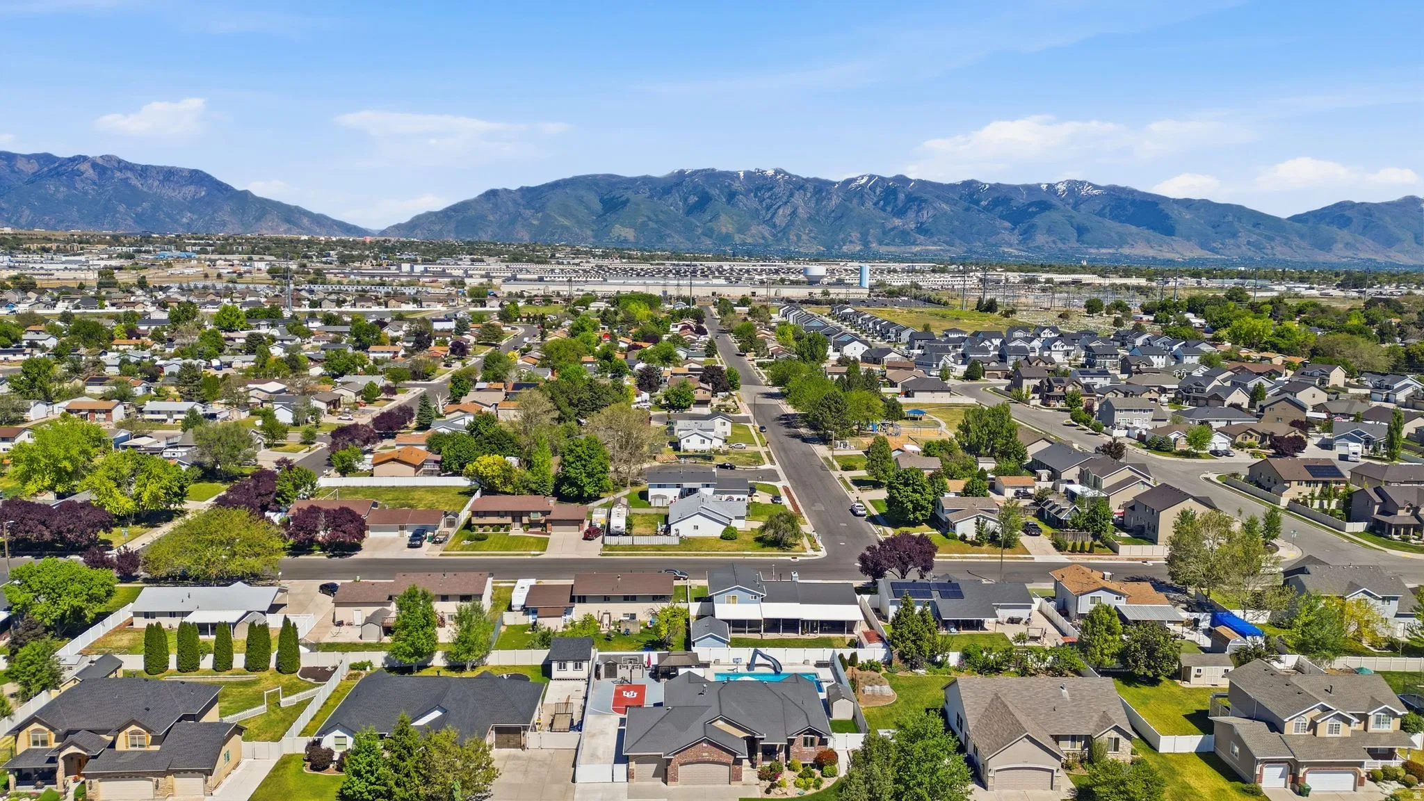 Expansive neighborhood showcasing diverse residential architecture and mature trees, set against a backdrop of distant mountains