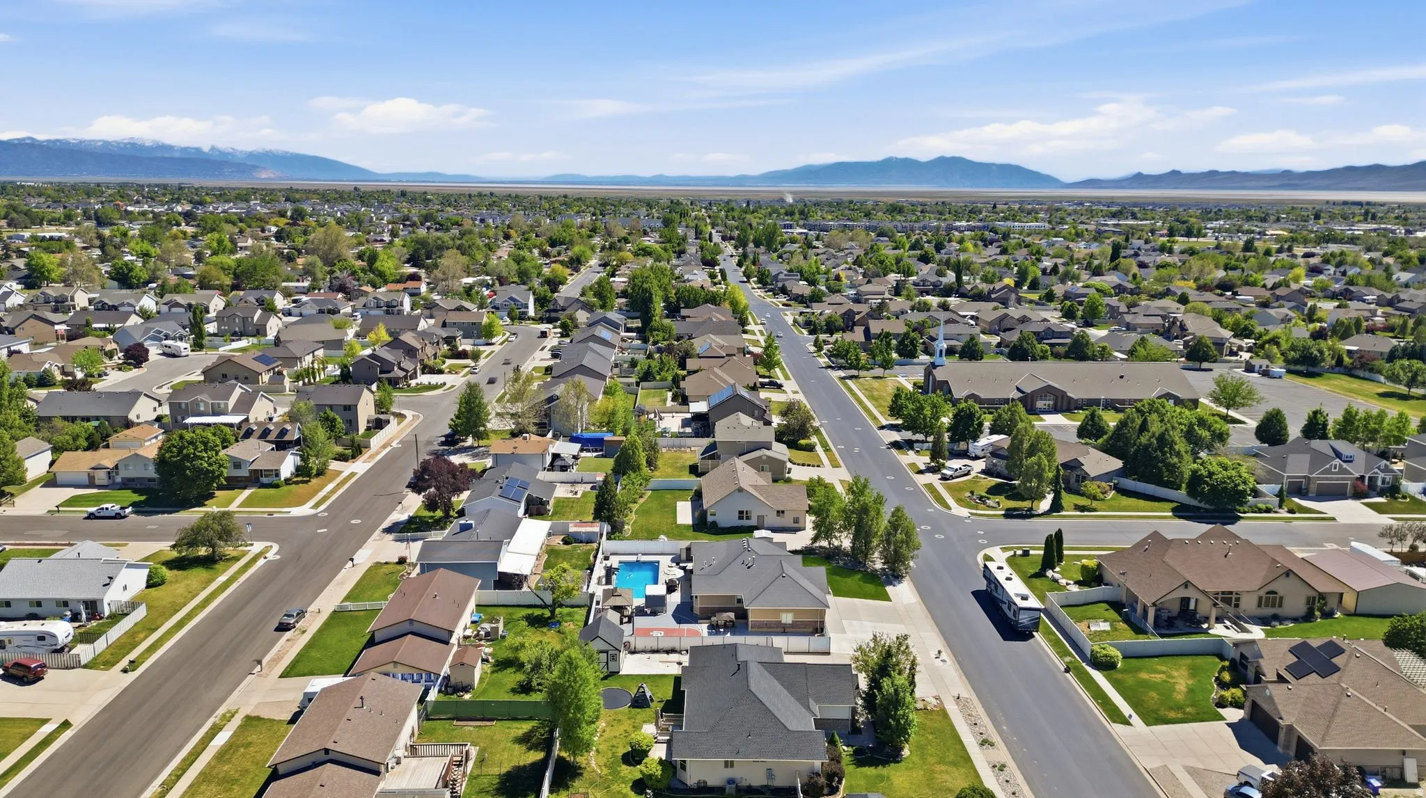 Expansive aerial perspective showcasing a residential neighborhood with mature landscaping and well-maintained streets