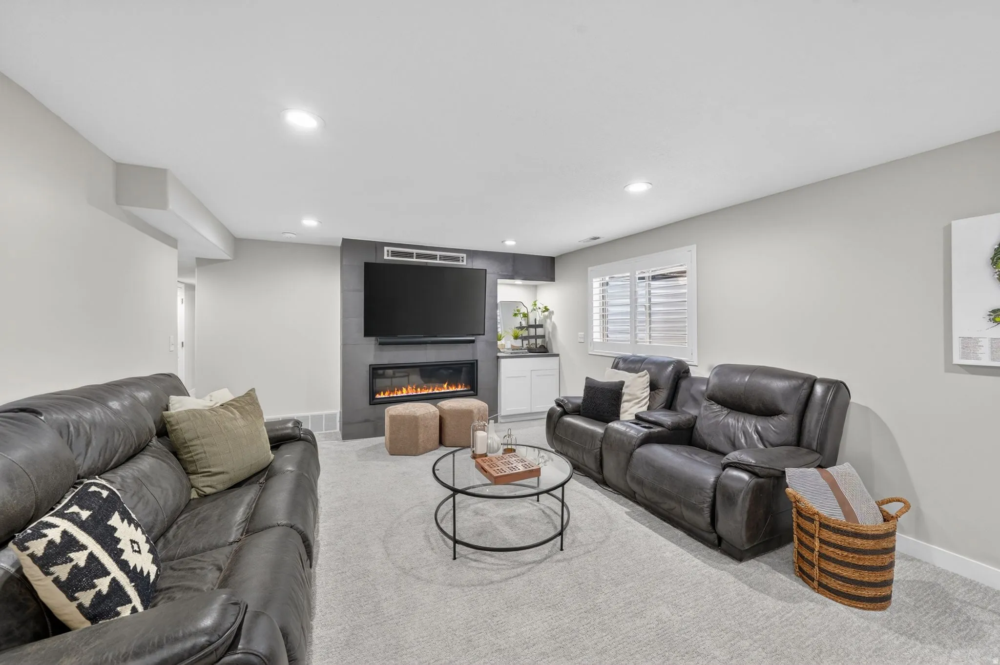 Spacious living area featuring light gray walls and plush carpeting