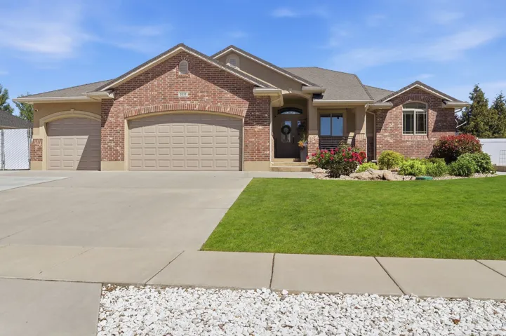 Brick and stucco exterior featuring multiple gables, an arched entry, and a covered porch