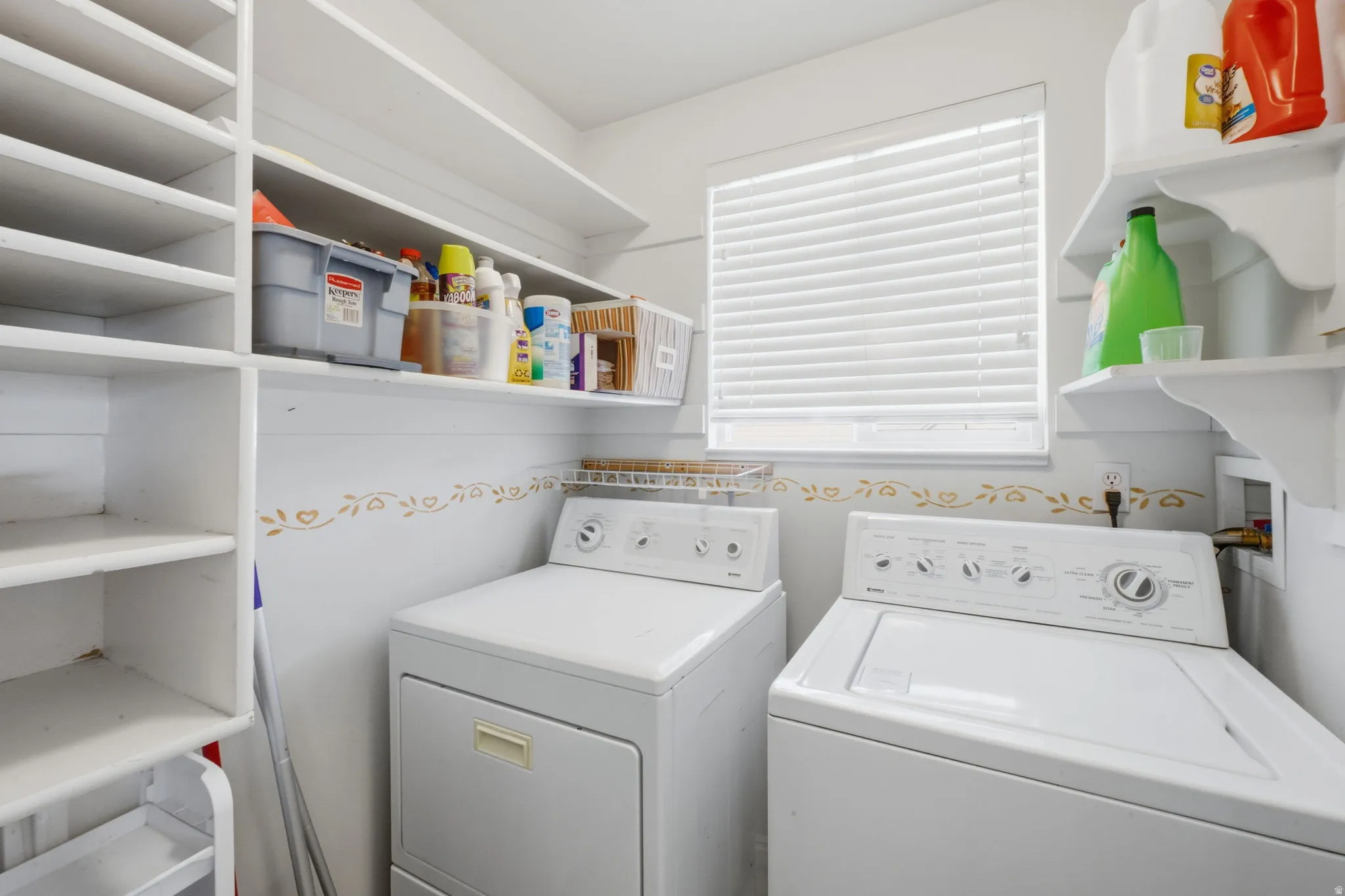Dedicated laundry area with built-in shelving, a window, and wall-mounted shelves