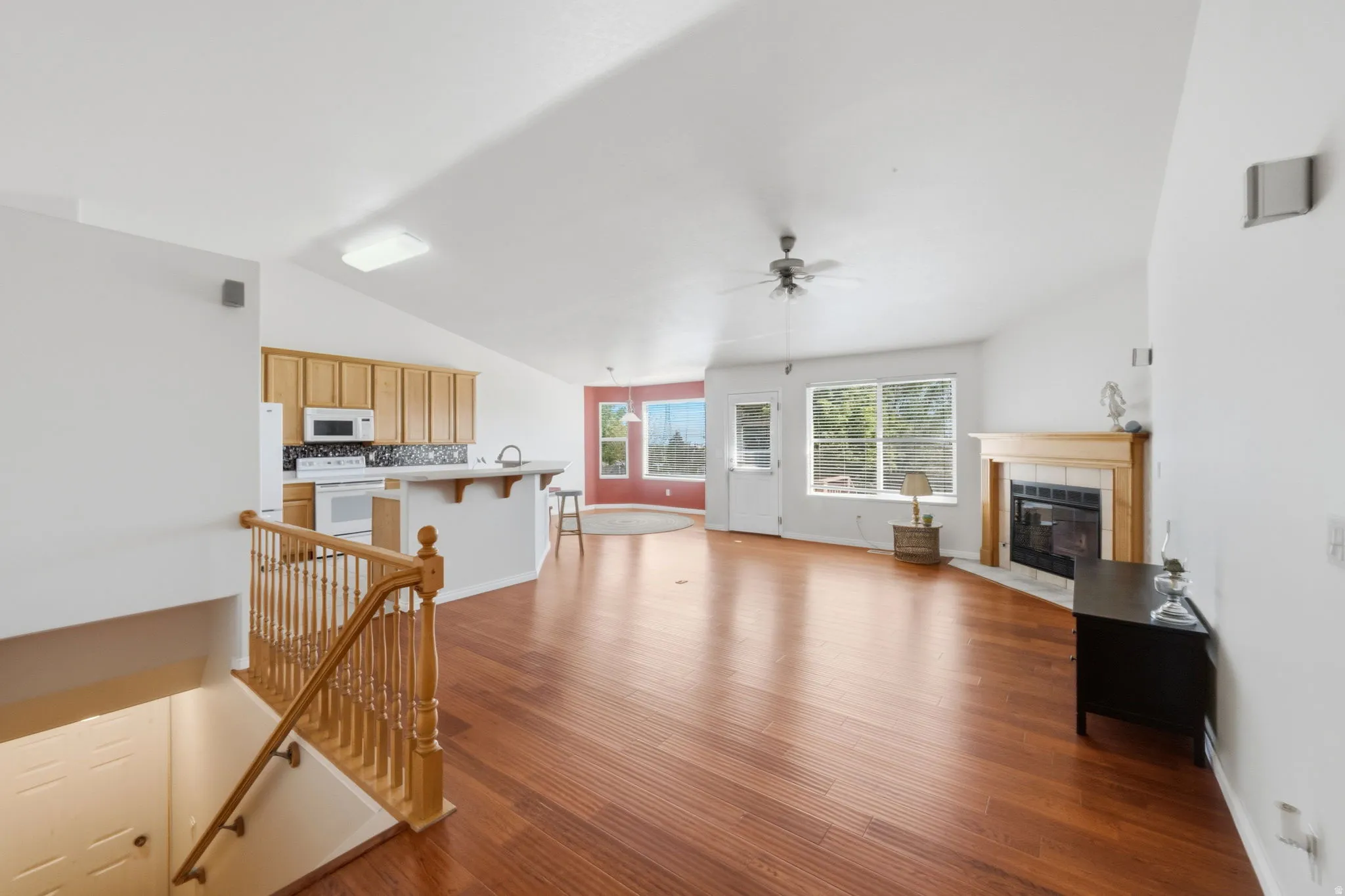 Open concept living area featuring wood-finish flooring and vaulted ceilings