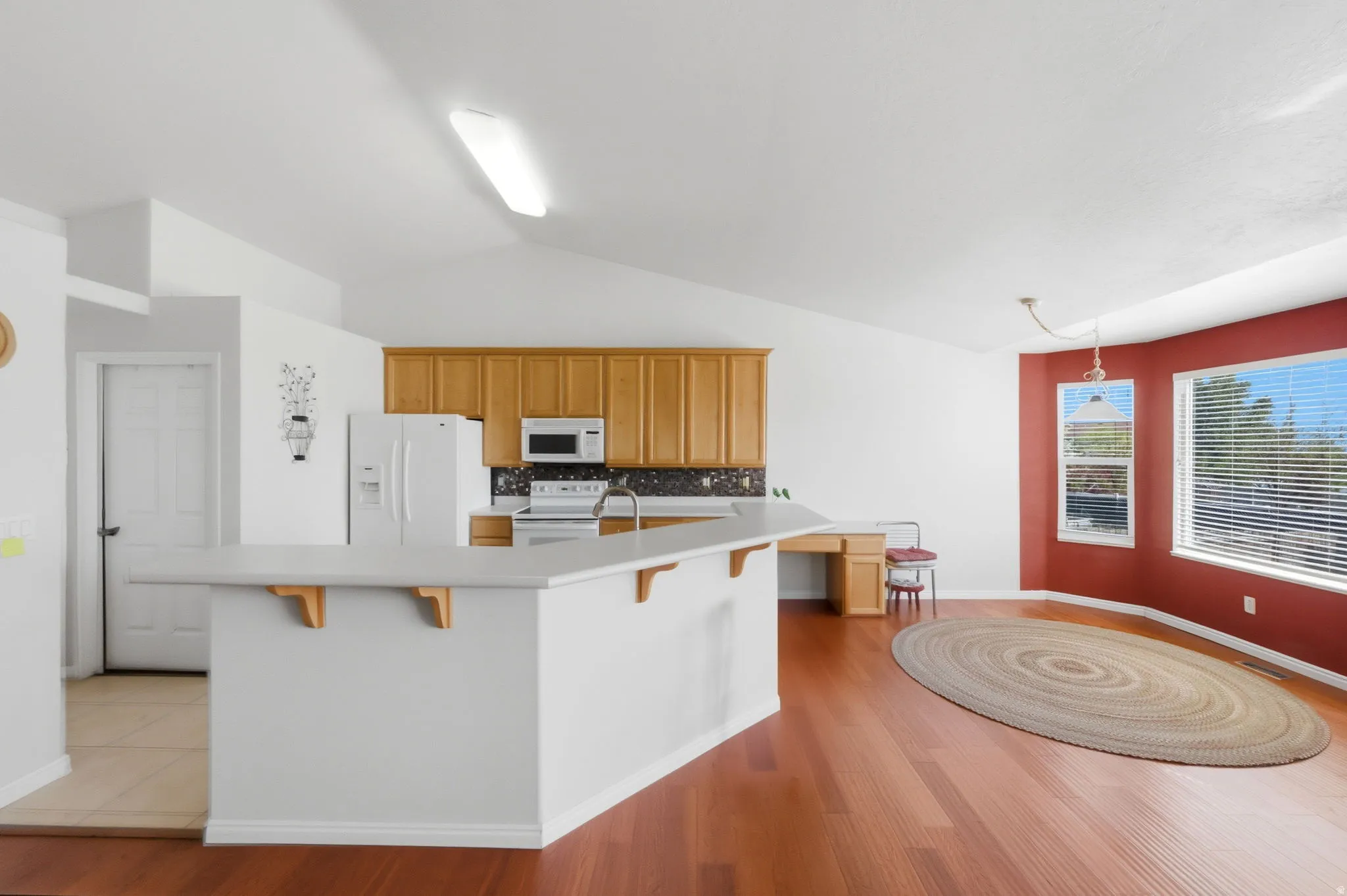 Open concept room featuring a kitchen, dining area, and wood-finish flooring