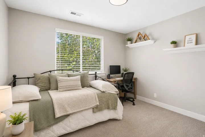 Carpeted room featuring a large window with blinds, light gray wall paint, and white trim