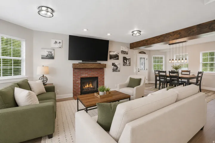 Living area featuring a brick fireplace with a wood-finish mantel, wood-finish flooring, and recessed lighting