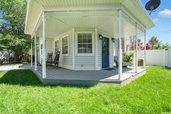 Covered porch with white columns, light blue siding, and a contrasting blue entry door