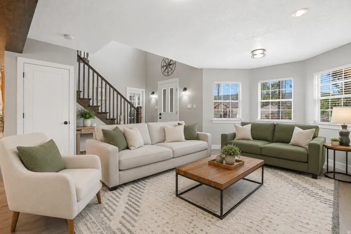 Open-concept living area featuring a vaulted ceiling and an abundance of natural light from multiple windows