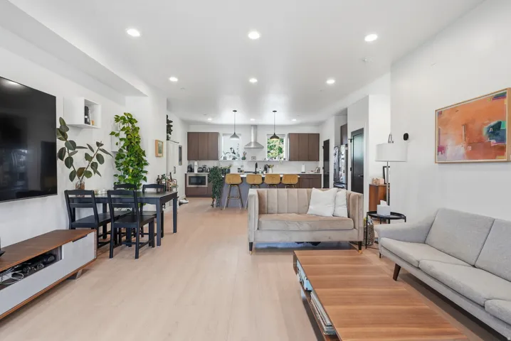 Open-concept living space featuring wood-finish flooring and recessed lighting