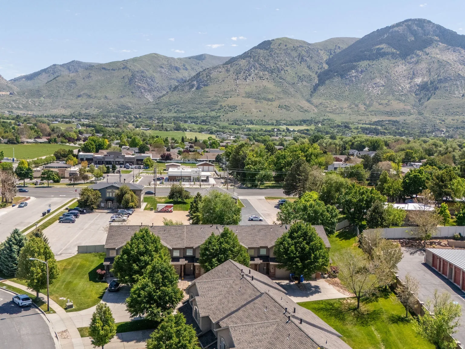 Aerial perspective showcasing multiple residential structures with pitched roofs and surrounding mature trees