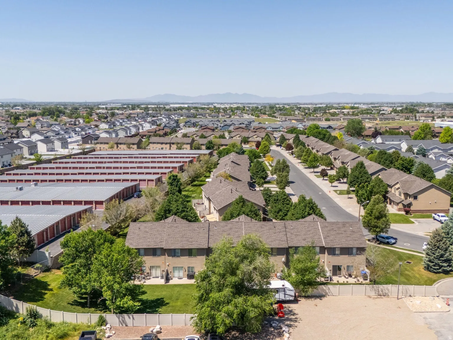 Residential area featuring multi-story townhomes with private patios and mature landscaping