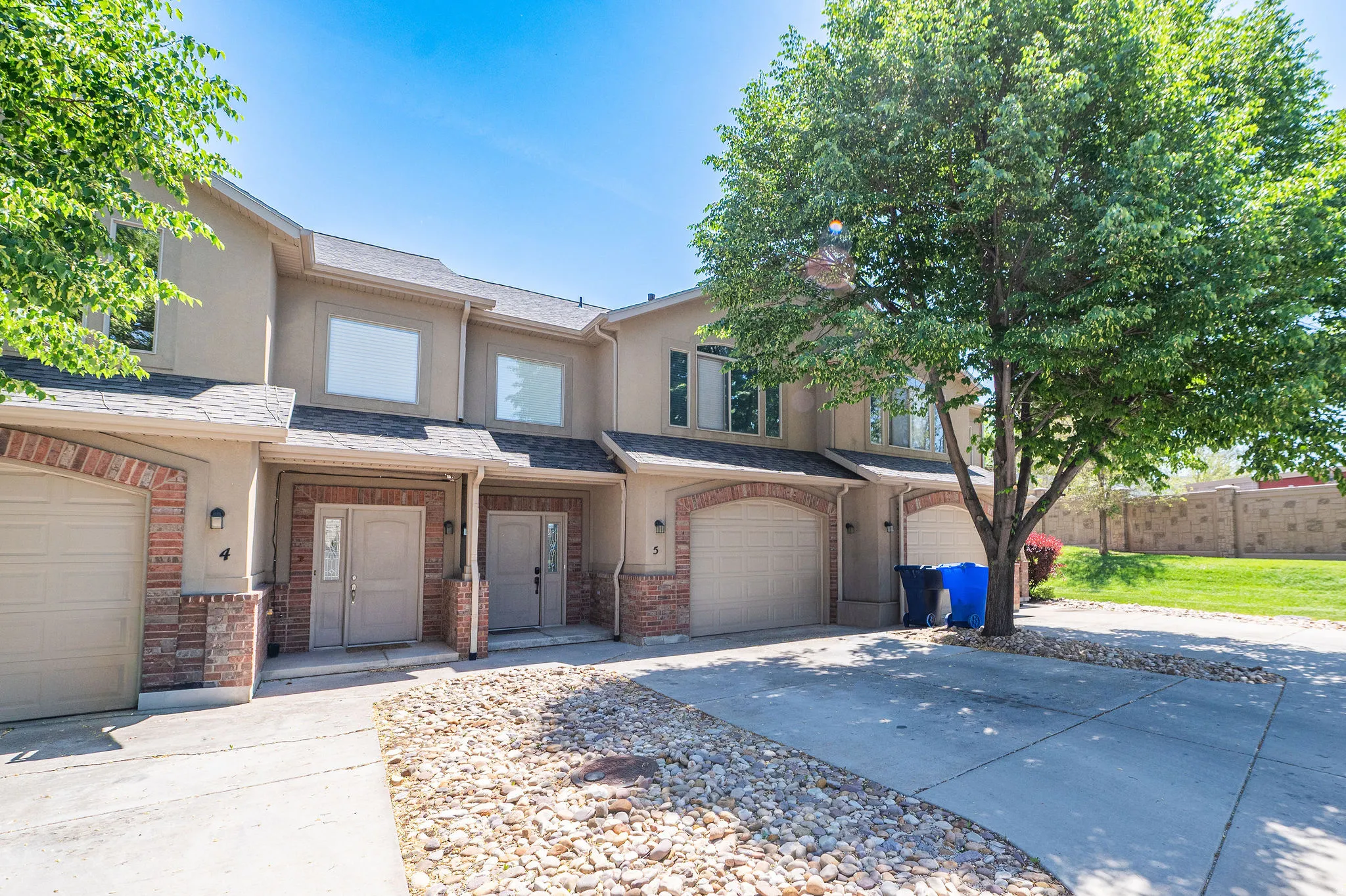 Multi-unit exterior with tan stucco siding and brick accents