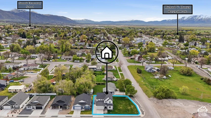Aerial overview of a residential area featuring a distinct property with an outlined lot