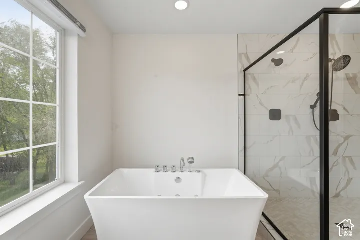 Freestanding soaking tub with polished chrome fixtures
