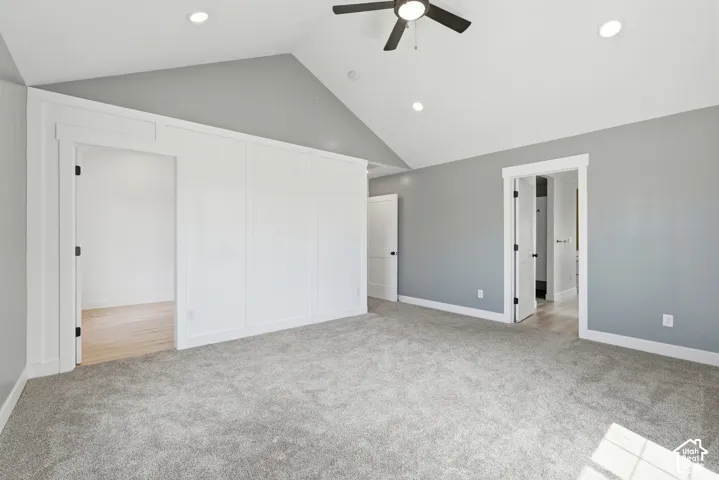 Spacious room featuring vaulted ceilings with recessed lighting and a ceiling fan