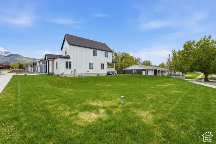 Expansive green lawn surrounding a modern vertical-panel siding residence