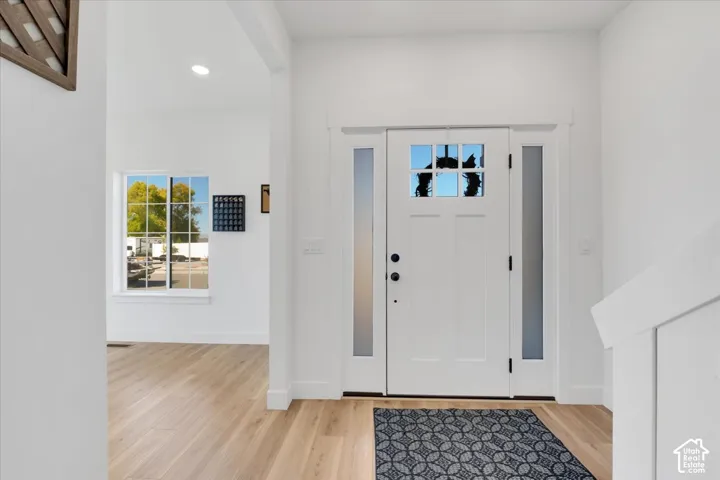 Entryway featuring a Craftsman-style door with clear glass panes, two frosted sidelights, and a transom window above