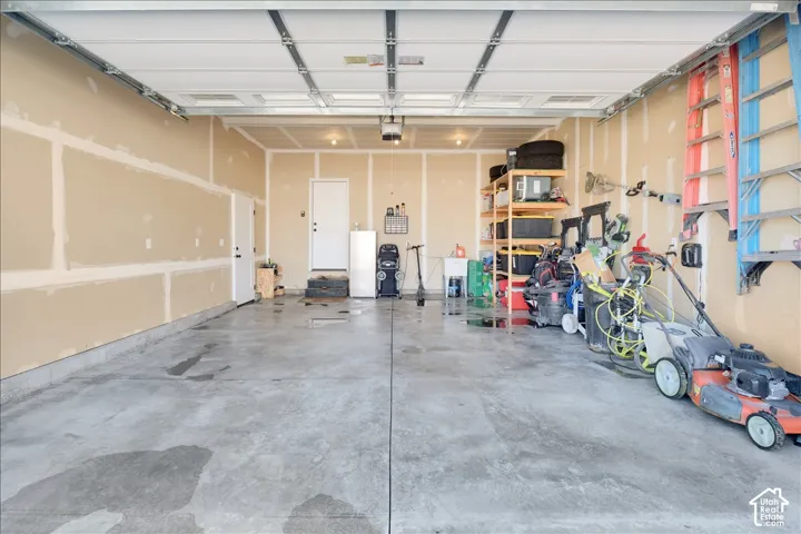 Spacious garage with concrete flooring and exposed drywall