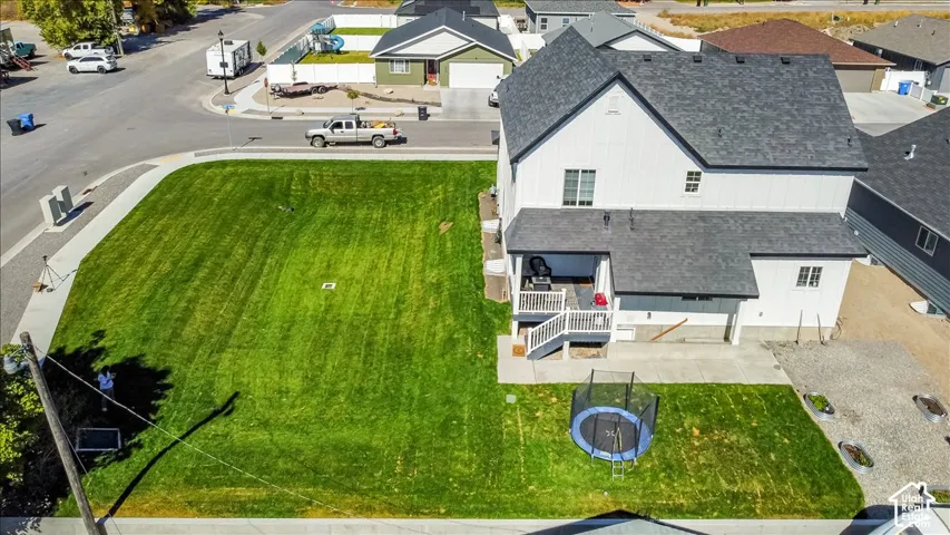 Expansive corner lot featuring a contemporary two-story residence with white vertical siding and dark gray shingle roofing